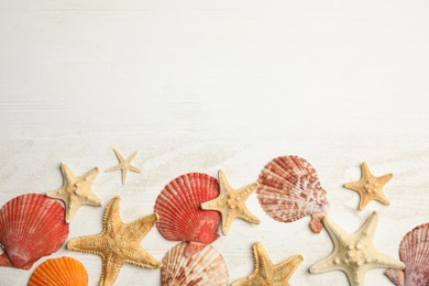 Beautiful sea stars, shells and sand on white wooden background, flat lay. Space for text Photo of Beautiful sea stars, shells and sand on white wooden background, flat lay. Space for text