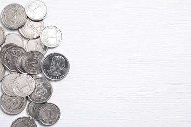 Ukrainian coins on white wooden background, flat lay. Space for text Photo of Ukrainian coins on white wooden background, flat lay. Space for text