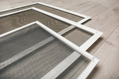 Set of window screens on wooden floor, closeup Photo of Set of window screens on wooden floor, closeup