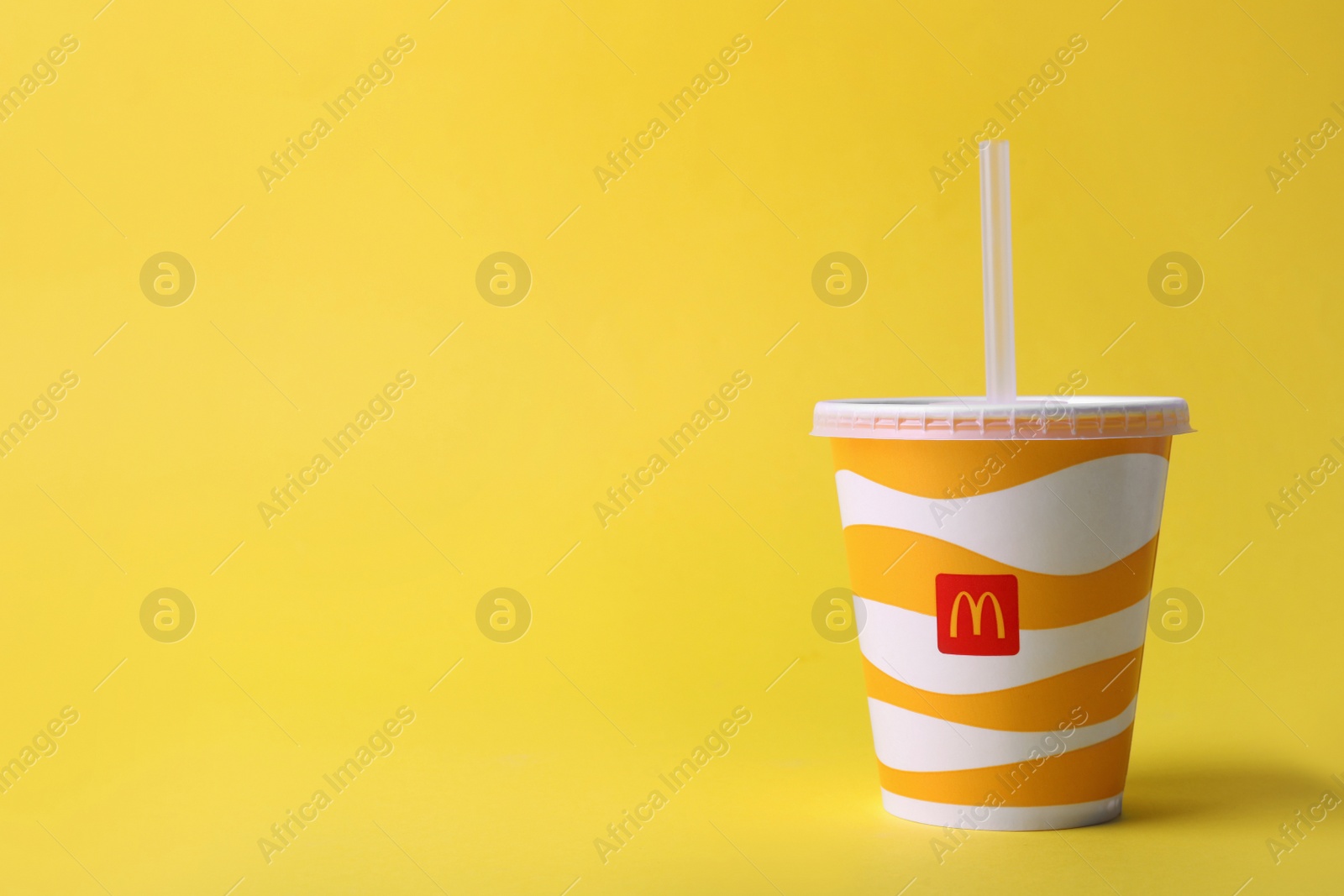 MYKOLAIV, UKRAINE - AUGUST 12, 2021: Cold McDonald's drink on yellow background. Space for text Photo of MYKOLAIV, UKRAINE - AUGUST 12, 2021: Cold McDonald's drink on yellow background. Space for text