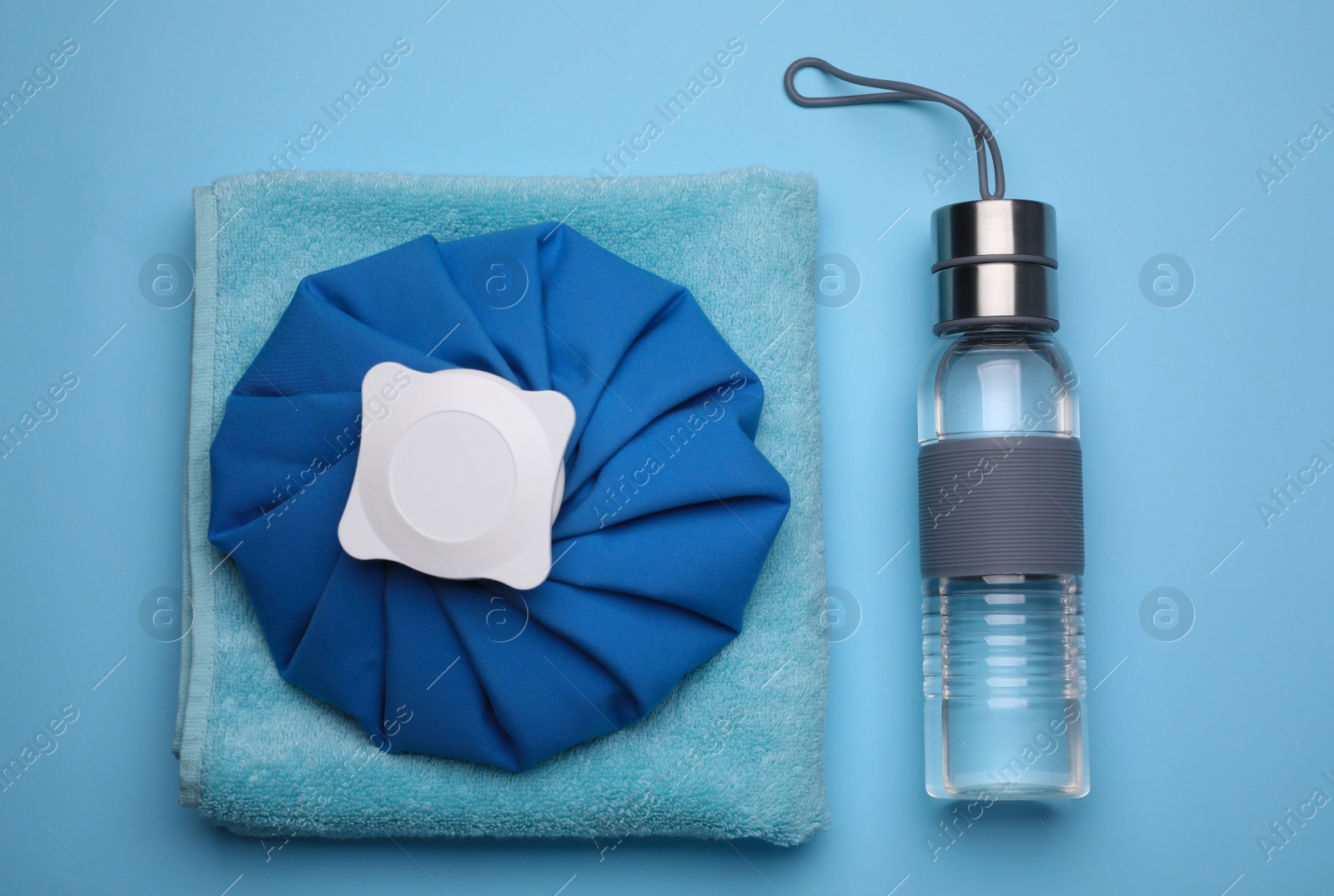 Bottle of water, cold compress and towel on light blue background, flat lay. Heat stroke treatment Photo of Bottle of water, cold compress and towel on light blue background, flat lay. Heat stroke treatment
