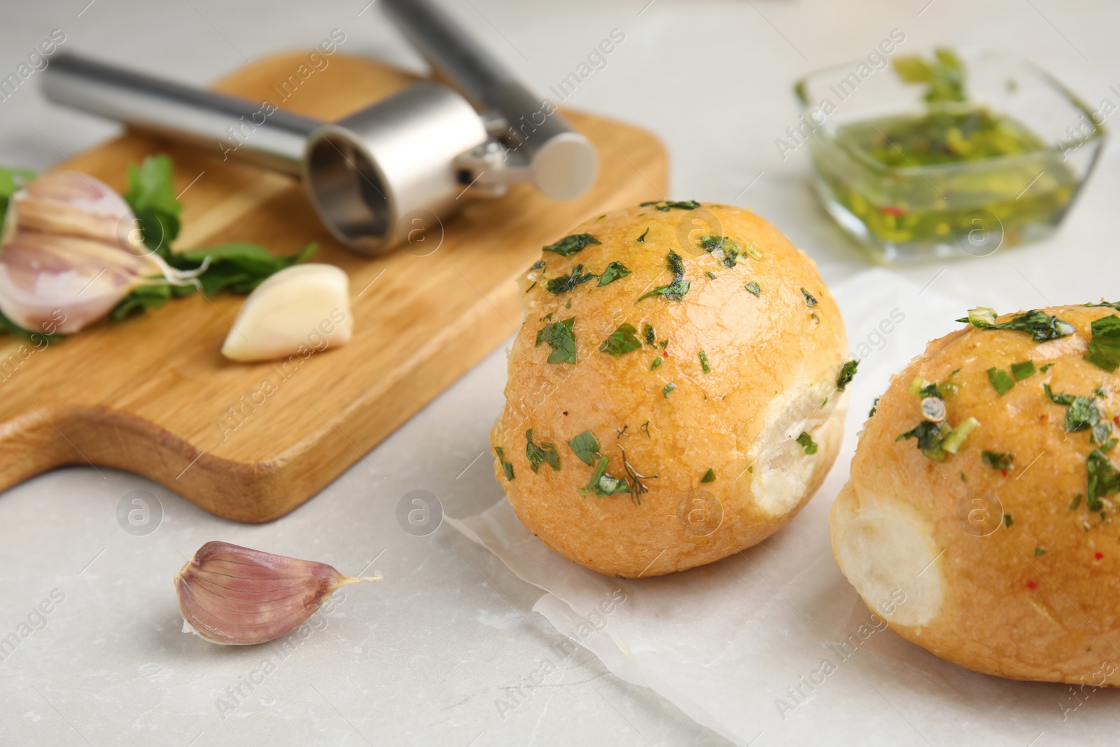 Traditional Ukrainian bread (Pampushky) with garlic on light table Photo of Traditional Ukrainian bread (Pampushky) with garlic on light table