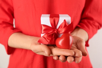 Woman holding gift box and red heart, closeup. Valentine's Day celebration Photo of Woman holding gift box and red heart, closeup. Valentine's Day celebration