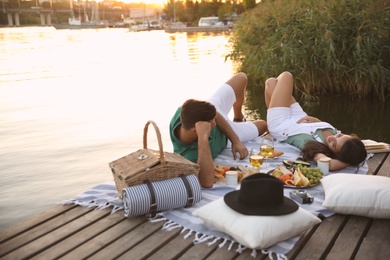 Happy couple spending time on pier at picnic Photo of Happy couple spending time on pier at picnic