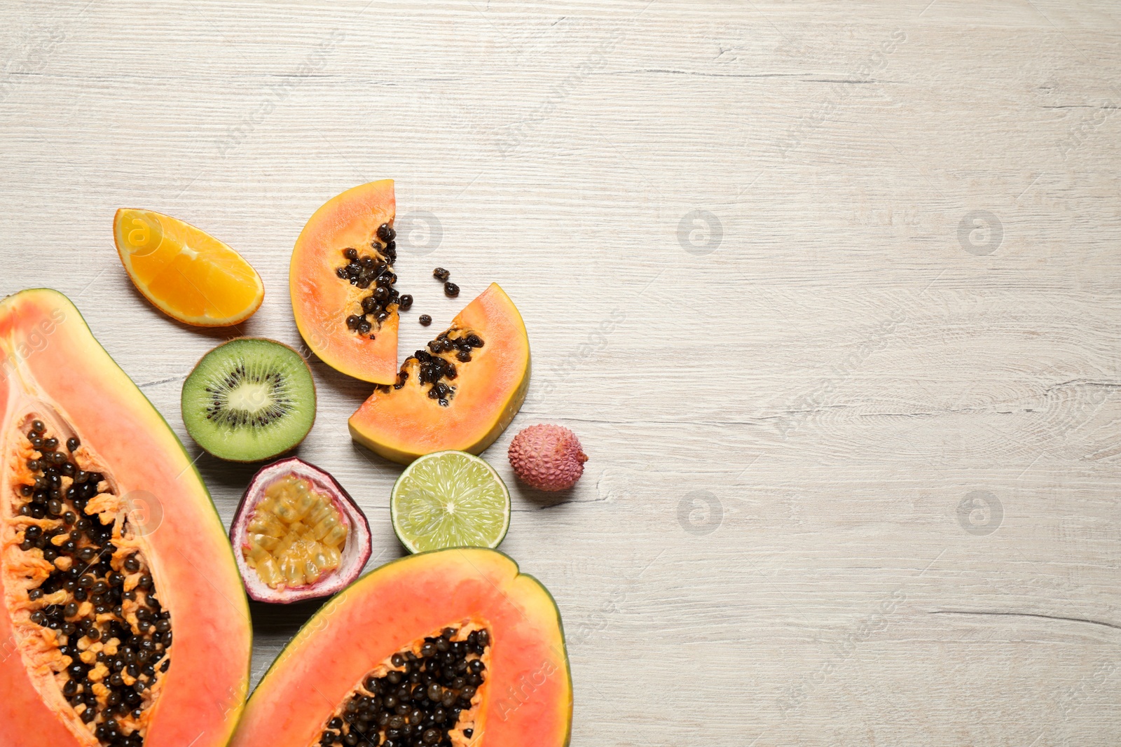 Fresh ripe papaya and other fruits on wooden table, flat lay. Space for text Photo of Fresh ripe papaya and other fruits on wooden table, flat lay. Space for text