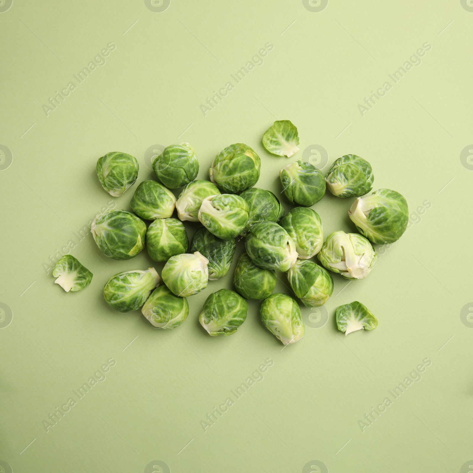 Fresh Brussels sprouts on green background, flat lay Photo of Fresh Brussels sprouts on green background, flat lay