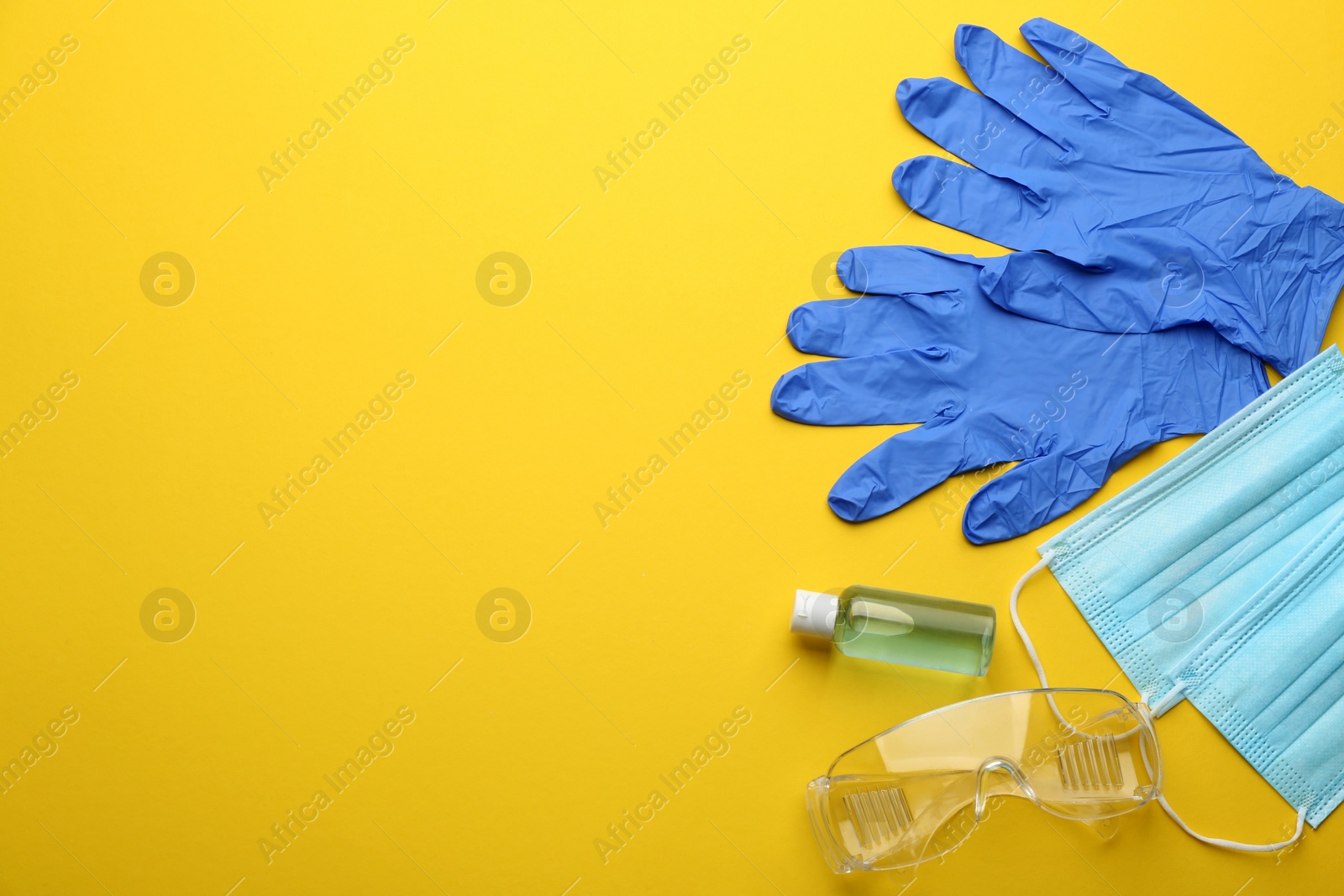 Flat lay composition with medical gloves, masks and hand sanitizer on yellow background. Space for text Photo of Flat lay composition with medical gloves, masks and hand sanitizer on yellow background. Space for text