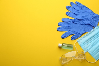 Flat lay composition with medical gloves, masks and hand sanitizer on yellow background. Space for text Photo of Flat lay composition with medical gloves, masks and hand sanitizer on yellow background. Space for text