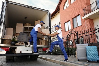 Workers unloading boxes from van outdoors. Moving service Photo of Workers unloading boxes from van outdoors. Moving service