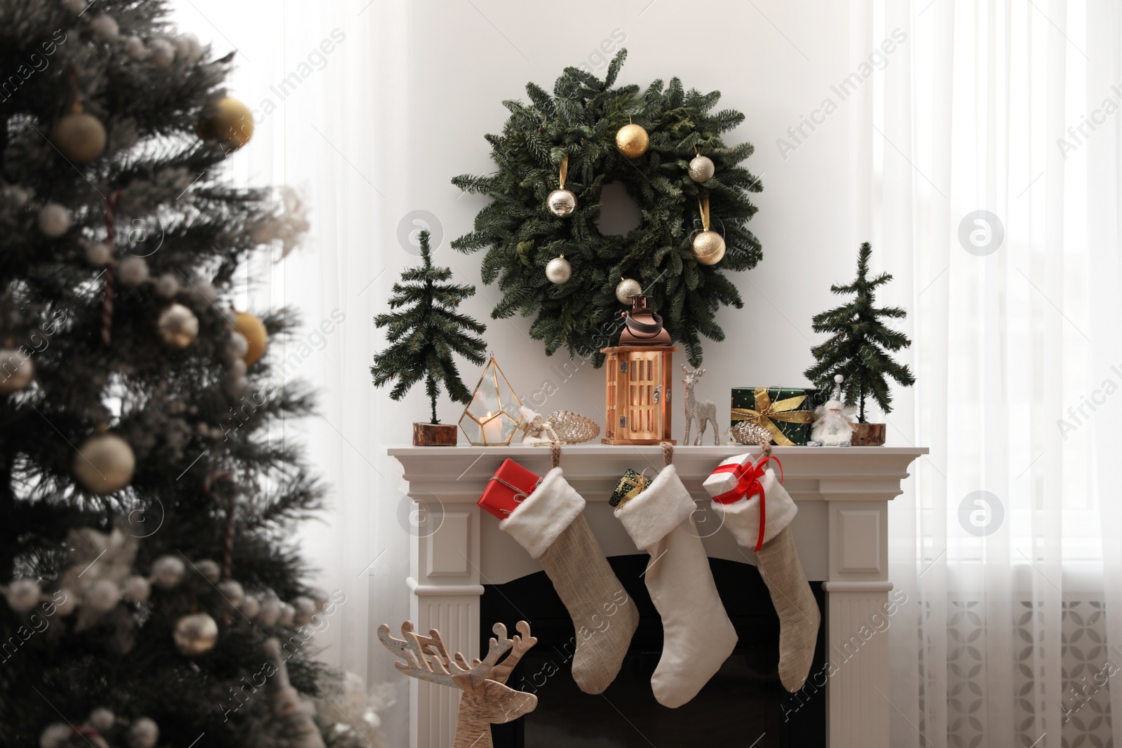 Fireplace in room with Christmas decorations. Interior design Photo of Fireplace in room with Christmas decorations. Interior design