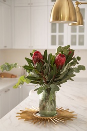 Bouquet with beautiful protea flowers on table in kitchen. Interior design Photo of Bouquet with beautiful protea flowers on table in kitchen. Interior design