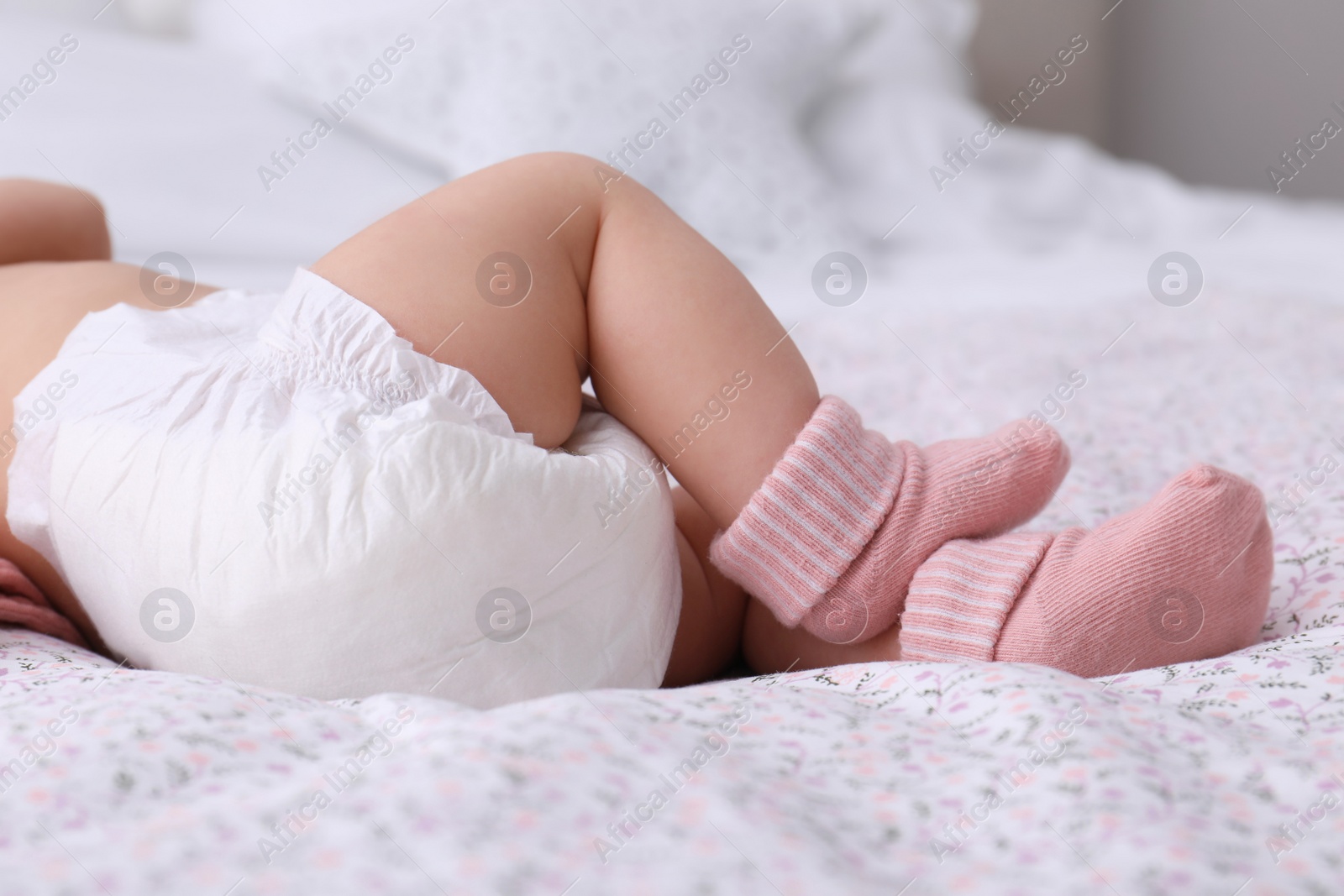 Photo of Little baby in diaper on bed, closeup