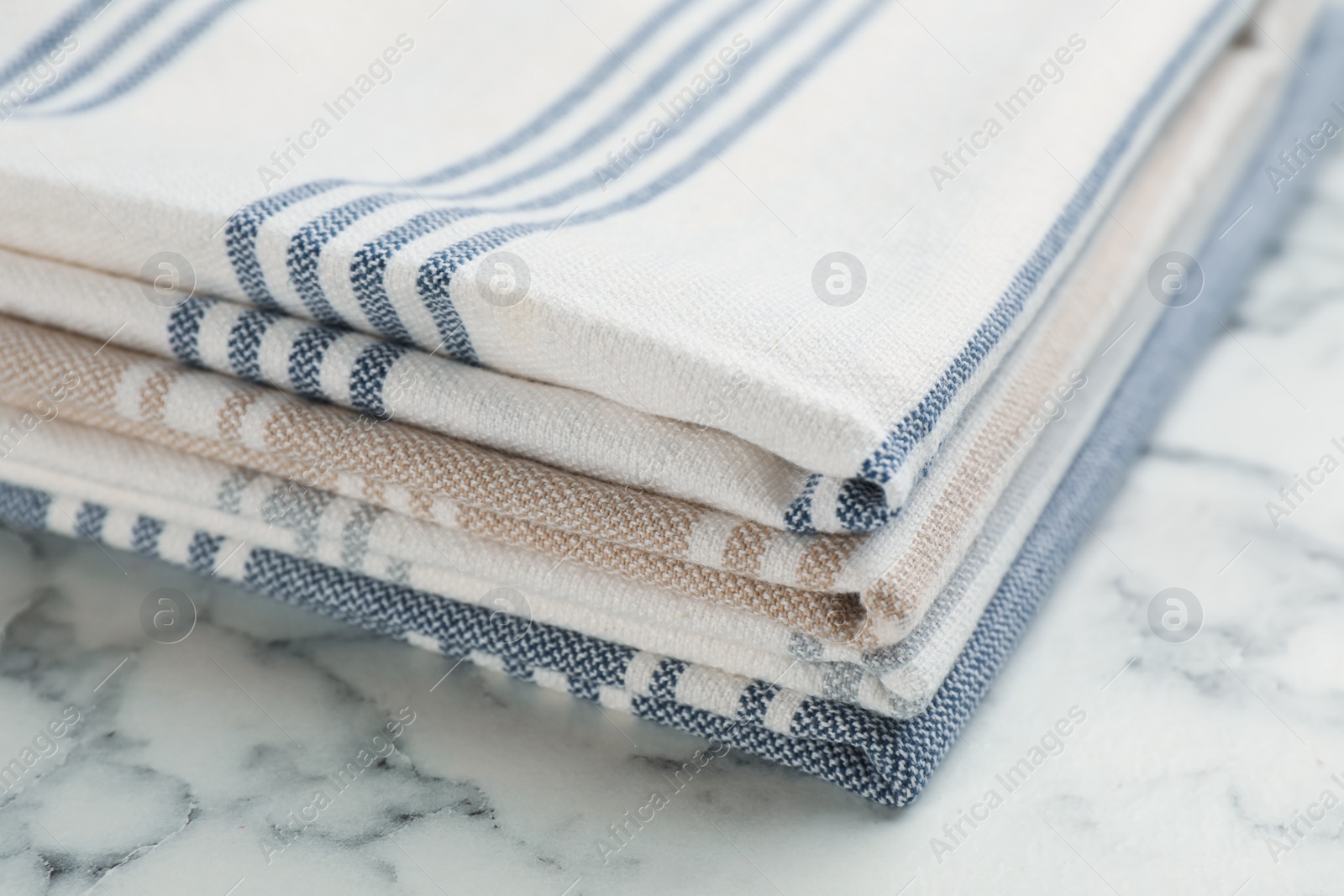 Stacked kitchen towels on white marble table, closeup Photo of Stacked kitchen towels on white marble table, closeup