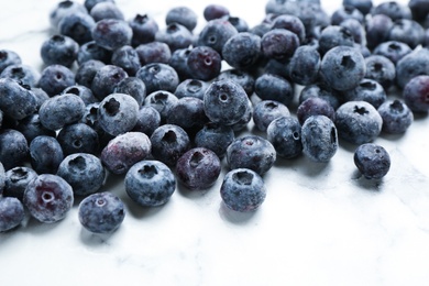 Tasty frozen blueberries on white marble table, closeup Photo of Tasty frozen blueberries on white marble table, closeup