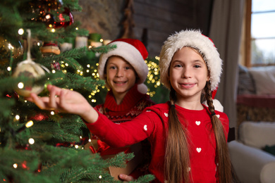 Happy children near beautiful Christmas tree at home Photo of Happy children near beautiful Christmas tree at home