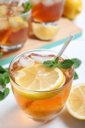 Delicious iced tea in glass on white table, closeup Photo of Delicious iced tea in glass on white table, closeup