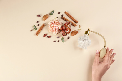 Woman with perfume. Fragrance composition, flowers and cinnamon on beige background, top view Photo of Woman with perfume. Fragrance composition, flowers and cinnamon on beige background, top view