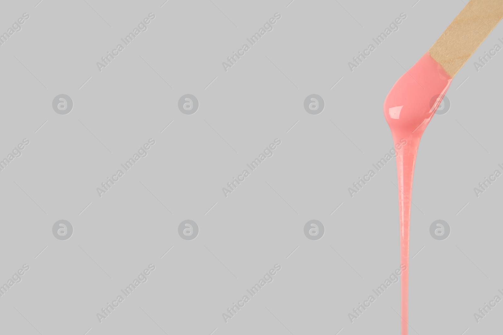 Wooden spatula with hot depilatory wax on light grey background. Space for text Photo of Wooden spatula with hot depilatory wax on light grey background. Space for text