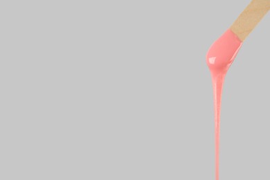 Wooden spatula with hot depilatory wax on light grey background. Space for text Photo of Wooden spatula with hot depilatory wax on light grey background. Space for text