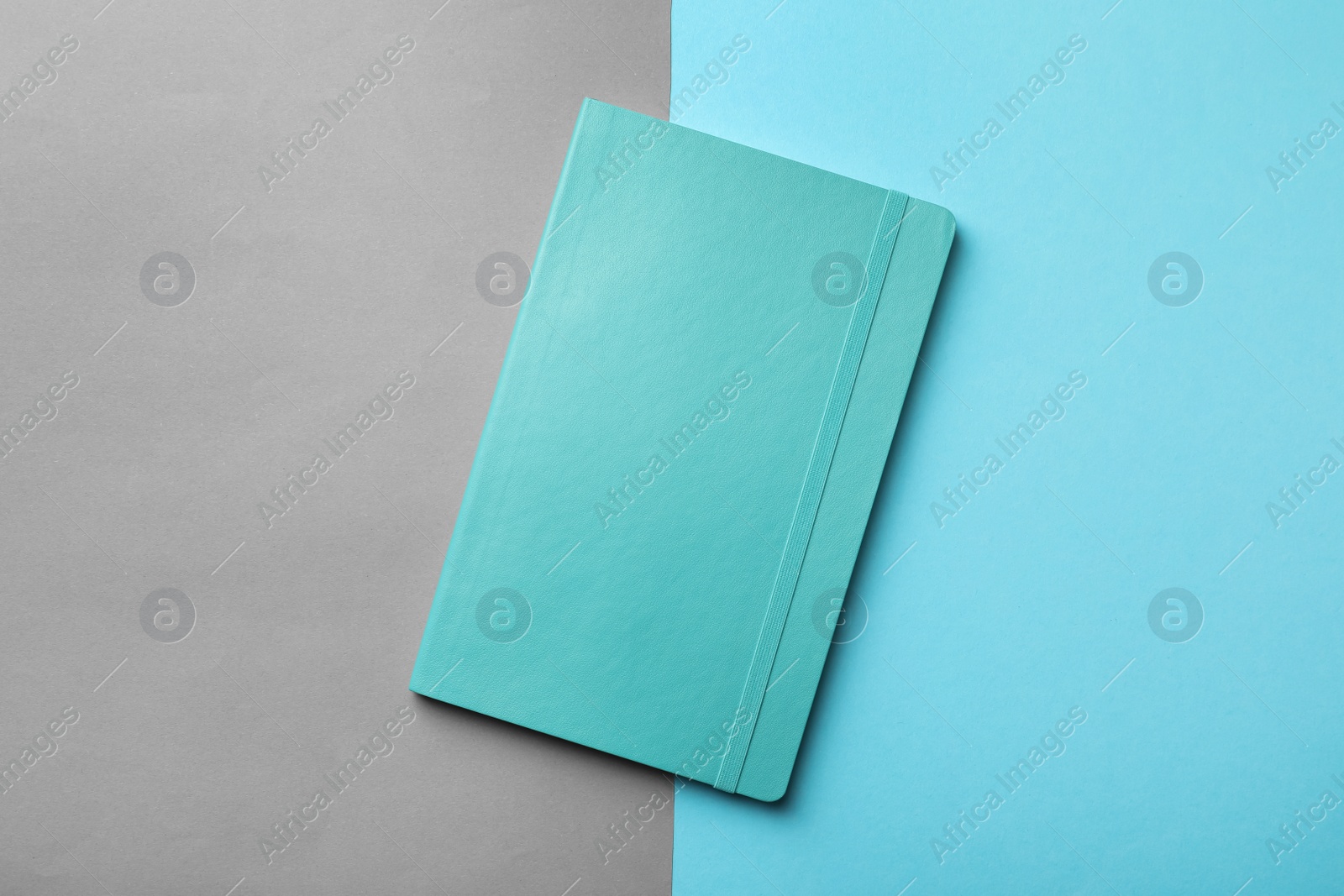 New stylish planner with hard cover on color background, top view Photo of New stylish planner with hard cover on color background, top view