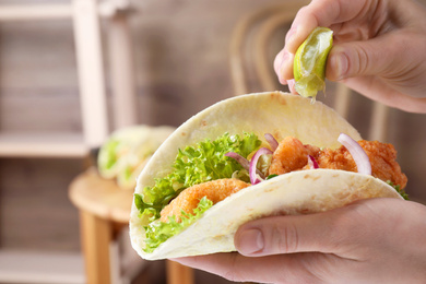 Woman squeezing lime on fish taco indoors, closeup Photo of Woman squeezing lime on fish taco indoors, closeup