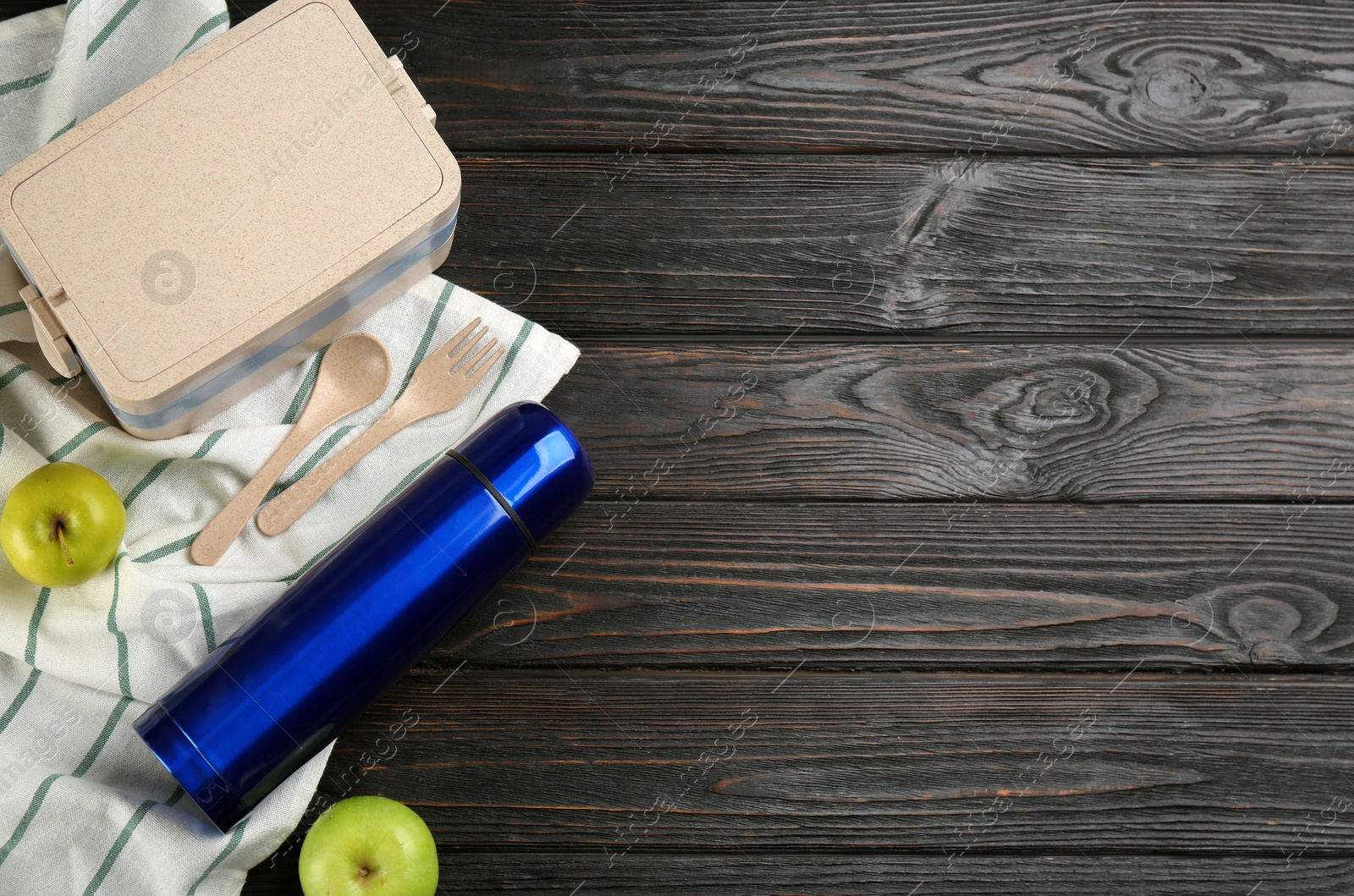 Thermos, lunch box and apples on black wooden table, flat lay. Space for text Photo of Thermos, lunch box and apples on black wooden table, flat lay. Space for text