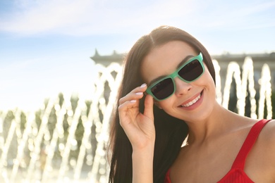Beautiful young woman wearing stylish sunglasses outdoors. Space for text Photo of Beautiful young woman wearing stylish sunglasses outdoors. Space for text