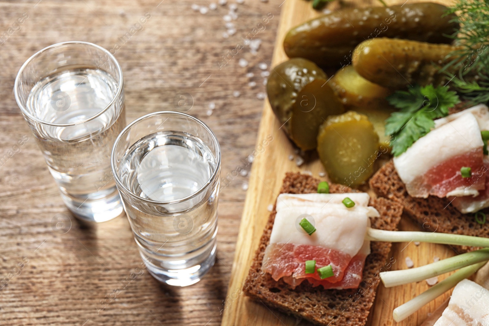 Cold Russian vodka with snacks on wooden table, above view Photo of Cold Russian vodka with snacks on wooden table, above view