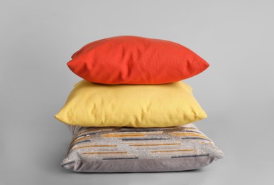 Stack of stylish soft pillows on grey background Photo of Stack of stylish soft pillows on grey background