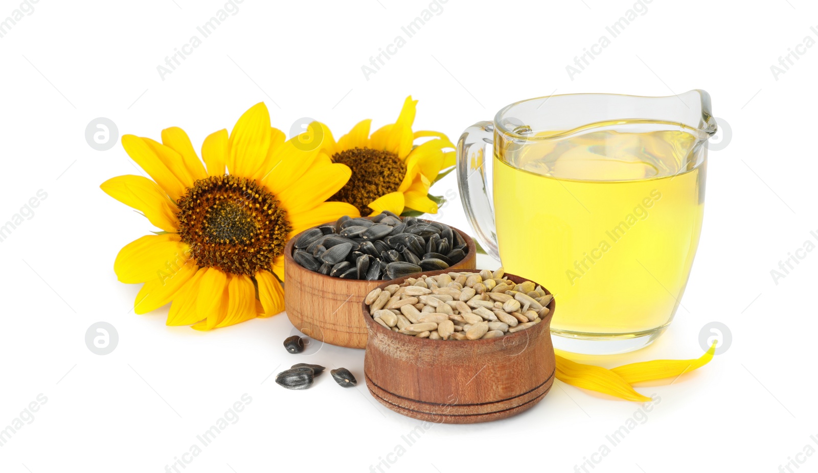 Sunflowers, jug of oil and seeds on white background Photo of Sunflowers, jug of oil and seeds on white background