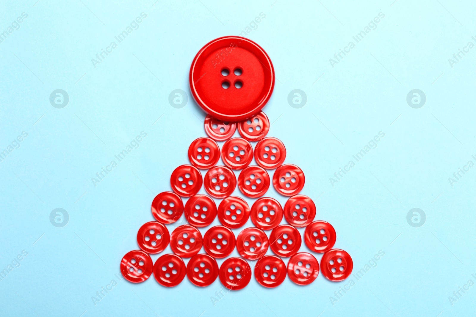 Christmas tree made with red buttons on light blue background, flat lay Photo of Christmas tree made with red buttons on light blue background, flat lay
