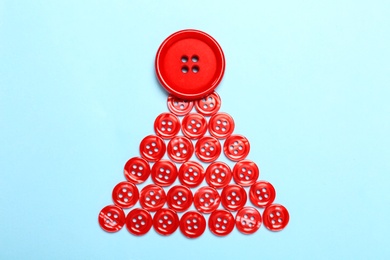 Christmas tree made with red buttons on light blue background, flat lay Photo of Christmas tree made with red buttons on light blue background, flat lay