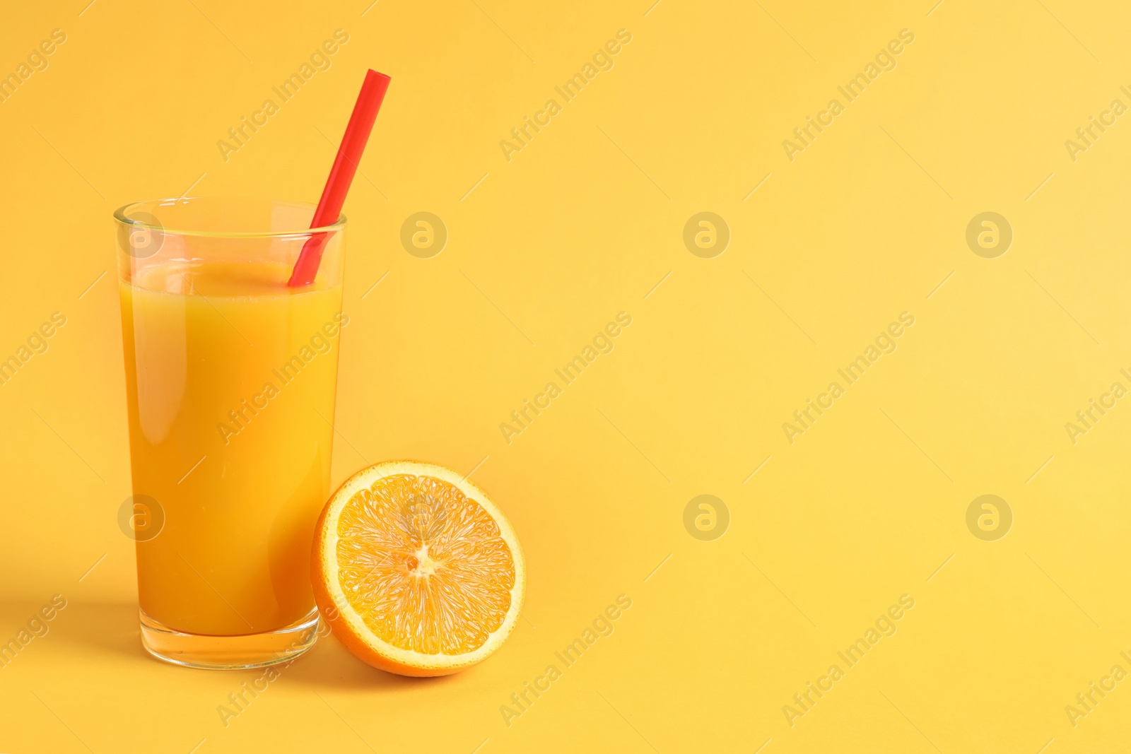 Glass of orange juice with fresh fruit on color background Photo of Glass of orange juice with fresh fruit on color background