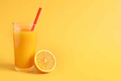 Glass of orange juice with fresh fruit on color background Photo of Glass of orange juice with fresh fruit on color background
