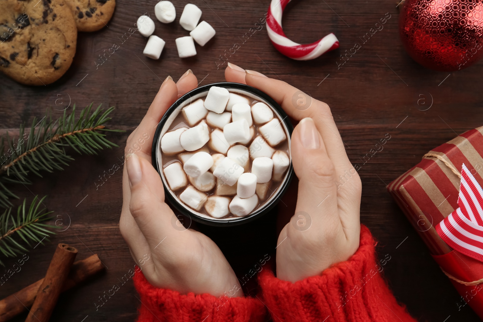 Woman with cup of delicious marshmallow cocoa at wooden table, top view Photo of Woman with cup of delicious marshmallow cocoa at wooden table, top view