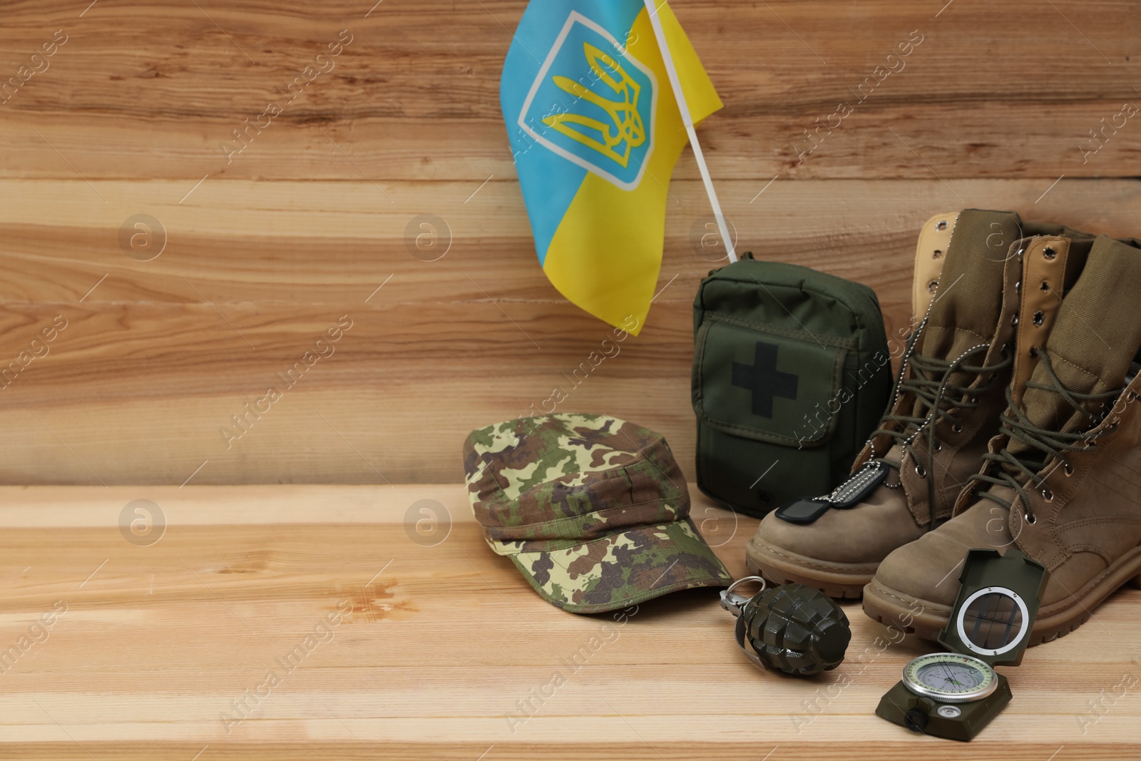 MYKOLAIV, UKRAINE - SEPTEMBER 26, 2020: Tactical gear and Ukrainian flag on wooden background. Space for text Photo of MYKOLAIV, UKRAINE - SEPTEMBER 26, 2020: Tactical gear and Ukrainian flag on wooden background. Space for text