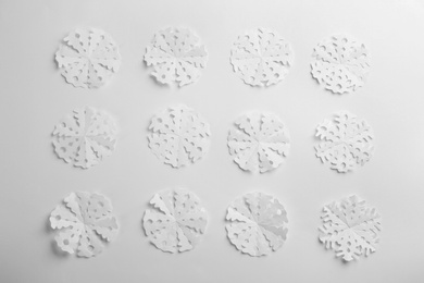 Many paper snowflakes on white background, flat lay Photo of Many paper snowflakes on white background, flat lay