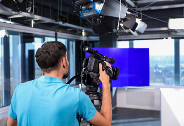 Photo of Professional video camera operator working in studio