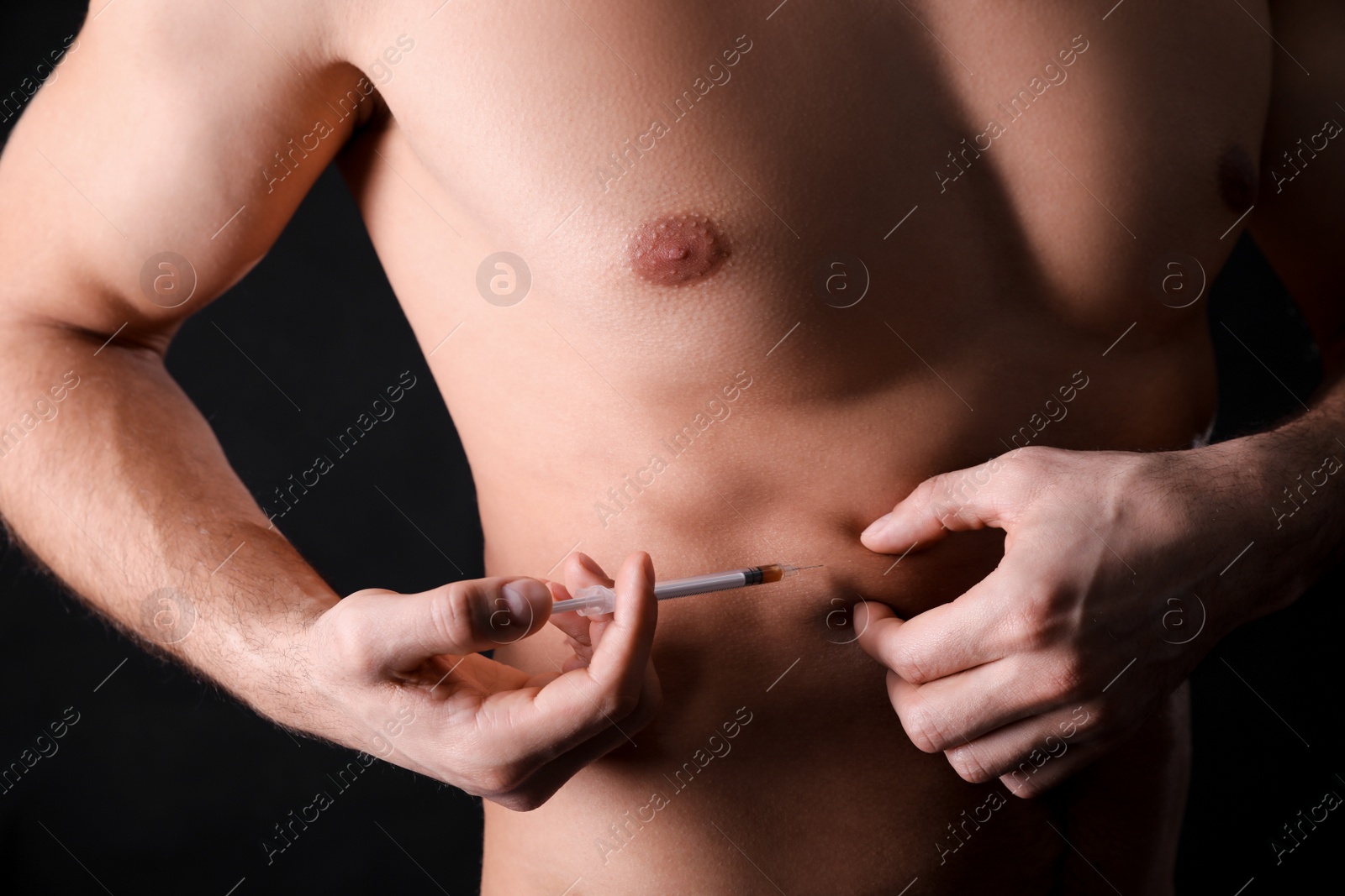 Athletic man injecting himself on black background, closeup. Doping concept Photo of Athletic man injecting himself on black background, closeup. Doping concept
