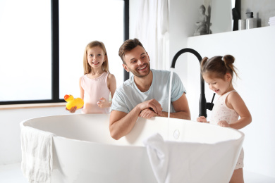Young father with little daughters in bathroom Photo of Young father with little daughters in bathroom