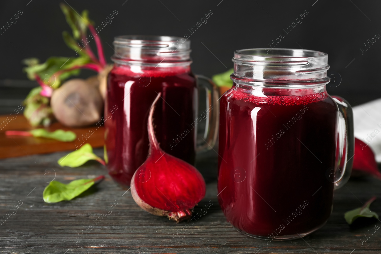 Fresh beet juice and raw vegetable on dark wooden table Photo of Fresh beet juice and raw vegetable on dark wooden table