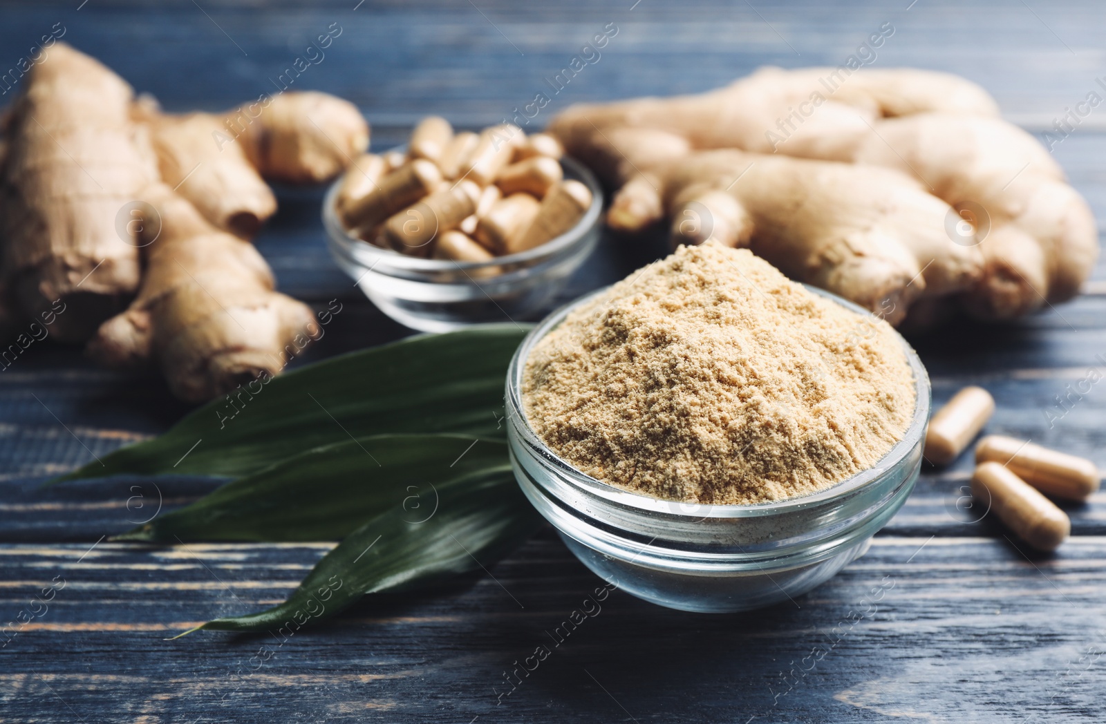 Dry, fresh and capsuled ginger on blue wooden table Photo of Dry, fresh and capsuled ginger on blue wooden table