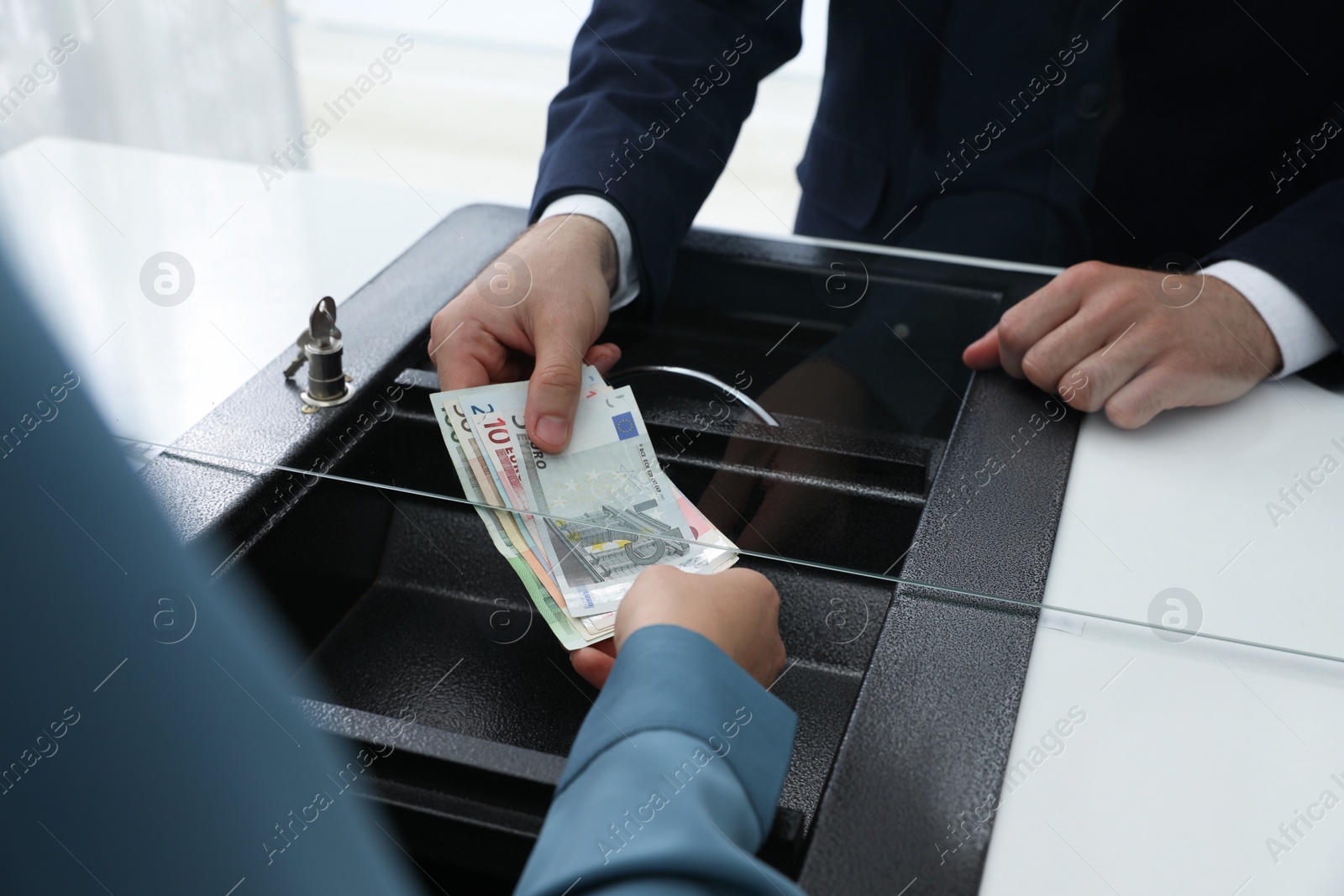 Woman giving money to cashier in bank, closeup. Currency exchange Photo of Woman giving money to cashier in bank, closeup. Currency exchange
