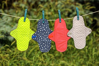 Many different menstrual cloth pads hanging on rope outdoors Photo of Many different menstrual cloth pads hanging on rope outdoors