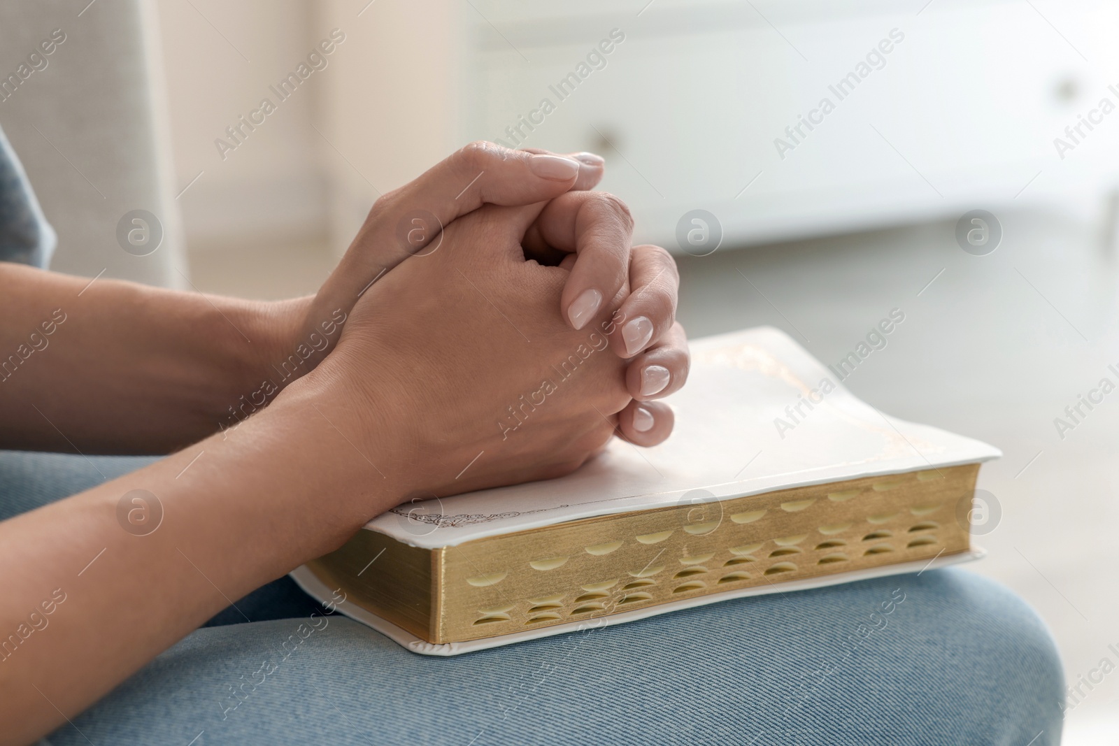 Religious woman with Bible praying indoors, closeup Photo of Religious woman with Bible praying indoors, closeup