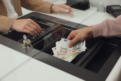 Man giving money to cashier in bank, closeup. Currency exchange Photo of Man giving money to cashier in bank, closeup. Currency exchange