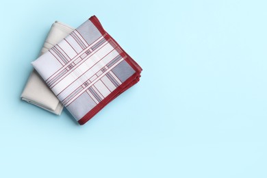 Stylish handkerchiefs on light blue background, flat lay. Space for text Photo of Stylish handkerchiefs on light blue background, flat lay. Space for text