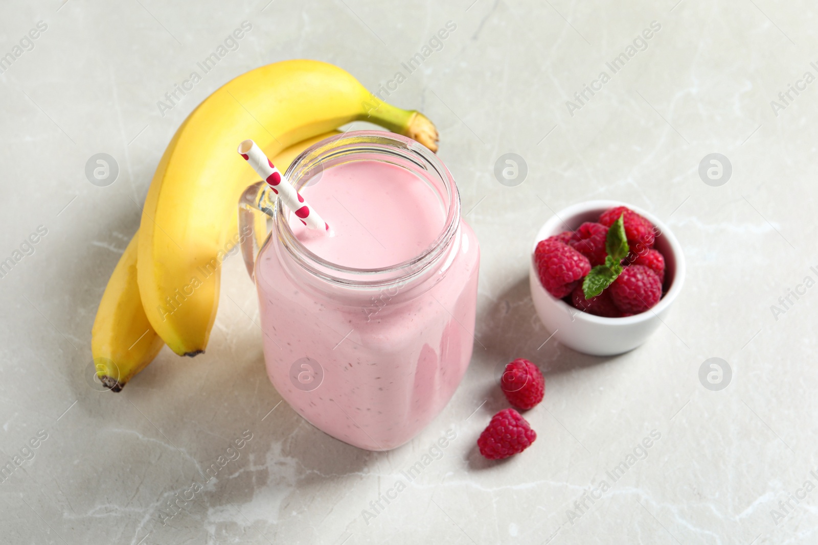 Freshly made raspberry smoothie in mason jar on marble table Image of Freshly made raspberry smoothie in mason jar on marble table
