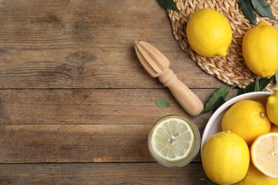 Squeezer with lemons on wooden table, flat lay. Space for text Photo of Squeezer with lemons on wooden table, flat lay. Space for text
