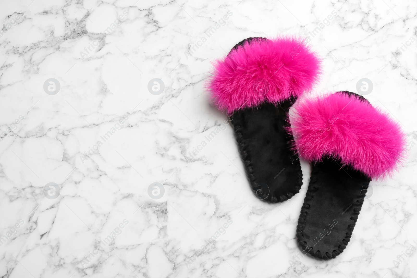Photo of Pair of soft slippers on white marble background, flat lay. Space for text